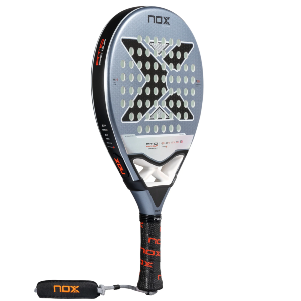 Der NOX AT10 Pro Cup Comfort 2025 Padelschläger zeichnet sich durch ein anspruchsvolles silber-schwarzes Design mit einem markanten „X“ in der Mitte aus, ergänzt durch kreisförmige Perforationen. Sein Griff ist schwarz, hervorgehoben durch das „NOX“-Logo in auffälligem Orange, und er ist mit einer Handschlaufe für besseren Halt ausgestattet.