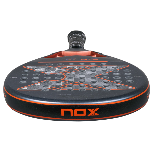 Der NOX AT10 Genius 18K 2025 von Agustin Tapia Padelschläger präsentiert sich in einem lebendigen schwarz-roten Design mit strukturierter Oberfläche und markantem Logo auf der Vorderseite. Sein Griff ist elegant in einen schlanken schwarzen Griff eingefasst und bietet außergewöhnliche Kontrolle, um Ihr Spiel zu verbessern.