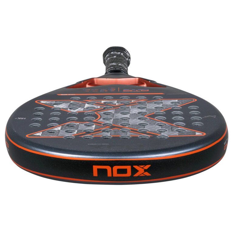 Eine Nahaufnahme des NOX AT10 Genius 18K 2025 von Agustin Tapia Padelschläger hebt sein schwarz-rotes Design, seine strukturierte Oberfläche und das „nox“-Branding hervor. Der runde Padelschläger weist kleine Löcher im Spielbereich auf, die seinen Griff und die Markendetails hervorheben.