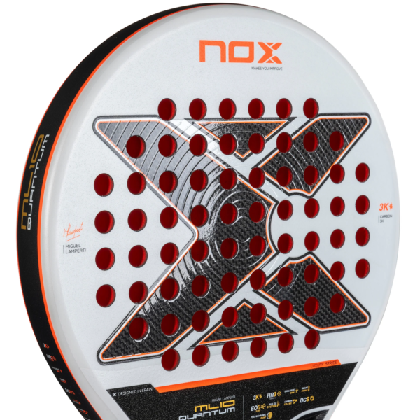 Nahaufnahme eines NOX ML10 QUANTUM 3K Miguel Lamperti Padelschläger Padelschlägers mit weißer Oberfläche mit roten runden Löchern und einem markanten „X“-Design in der Mitte. Der Rand ist mit orangefarbenen und schwarzen Akzenten verziert, die die Logos von Miguel Lamperti Padelschläger hervorheben.